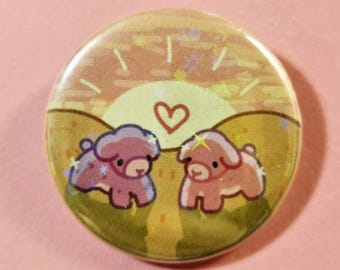 May include: A round button featuring two cartoon dogs in a field with a heart and a sunset background. The dogs are pink and light pink, with a yellow star above one. The background is yellow and orange.