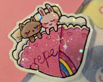May include: A sticker featuring a pink crepe with a rainbow and the word "crepe" in cursive. A brown cat and a pink bunny are on top of the crepe. The sticker has a holographic, glittery effect.