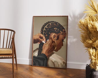 May include: A framed art print depicts a woman with intricately styled braids and gold hoop earrings. Hands are shown styling the hair. The artwork is set against a neutral background, with a wooden chair and decorative plant in the scene.