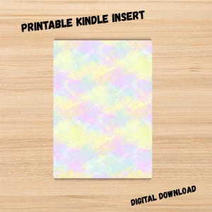 May include: A rectangular printable Kindle insert with a pastel watercolor design in shades of yellow, pink, and blue. The text "PRINTABLE KINDLE INSERT" is at the top, and "DIGITAL DOWNLOAD" is at the bottom.