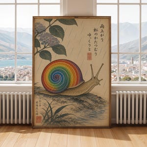 May include: Framed print of a snail with a rainbow shell, in the style of Japanese art. The artwork includes Japanese text and illustrations of rain, plants, and a snail on a rock. The print is displayed in a room with a window overlooking a city.