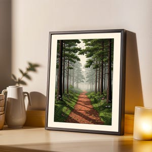 May include: Framed art print showing a forest scene. A red dirt path meanders through tall, green trees. The artwork is framed in a black border and rests on a wooden surface. A white jug and candle are visible.
