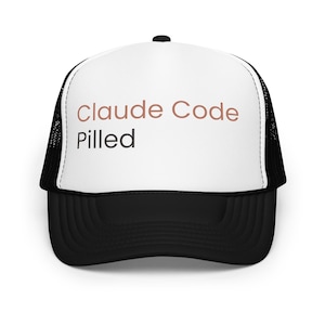 Pode incluir: Boné de caminhoneiro preto e branco com o texto "Claude Code Pilled" em marrom e preto. O boné apresenta um painel frontal branco e uma parte traseira de malha preta, com uma aba curva.