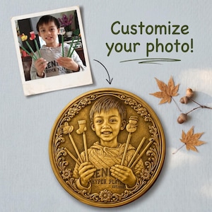 May include: A gold-colored, circular medallion with a portrait of a child holding pencils with Christmas-themed toppers. The medallion is surrounded by a floral border. The image includes the text "Customize your photo!"