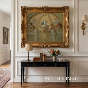 Pode incluir: Uma consola preta com três gavetas, detalhes dourados e uma pintura emoldurada por cima. A pintura tem uma moldura dourada ornamentada e retrata uma cena religiosa. Uma lâmpada, livros e um vaso de flores estão sobre a mesa. O texto "SMITH & IMAGO THE HEIRLOOM COLLECTION" está na parte inferior.