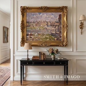 May include: A large, ornate gold framed painting of a cityscape hangs above a black desk with gold accents. A lamp, books, and a vase of flowers sit on the desk. The wall is white with decorative molding. The floor is hardwood.