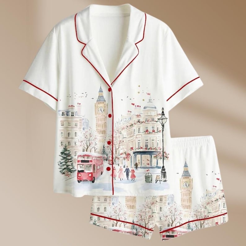 K&ouml;nnte beinhalten: Wei&szlig;es Pyjama-Set mit London-Motiv. Das kurz&auml;rmelige Oberteil und die Shorts zeigen eine Aquarellillustration von Big Ben, einem roten Doppeldeckerbus und anderen Londoner Wahrzeichen. Das Set ist mit roten Paspeln versehen.