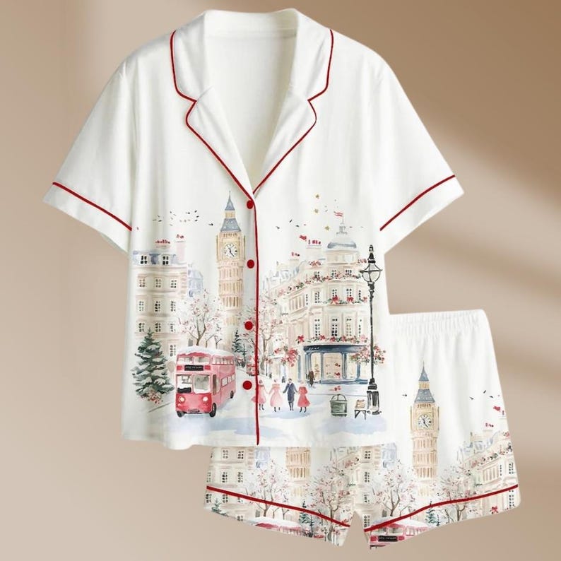 K&ouml;nnte beinhalten: Wei&szlig;es Pyjama-Set mit London-Motiv. Das kurz&auml;rmelige Oberteil und die Shorts zeigen eine Aquarellillustration von Big Ben, einem roten Doppeldeckerbus und anderen Londoner Wahrzeichen. Das Set ist mit roten Paspeln versehen.