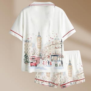 K&ouml;nnte beinhalten: Wei&szlig;es Pyjama-Set mit London-Motiv. Das kurz&auml;rmelige Oberteil und die Shorts zeigen eine Aquarellillustration von Big Ben, einem roten Doppeldeckerbus und anderen Londoner Wahrzeichen. Rote Paspeln.