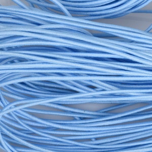 May include: A close-up of a pile of light blue elastic cord. The cord is soft and flexible, and it is ideal for crafting projects.