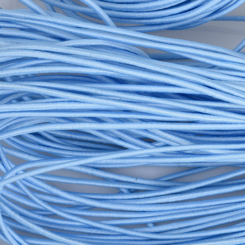 May include: A close-up of a pile of light blue elastic cord. The cord is soft and flexible, and it is ideal for crafting projects.