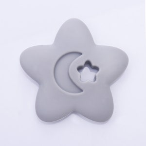 May include: A gray silicone baby teether shaped like a star with a crescent moon and a star cutout.