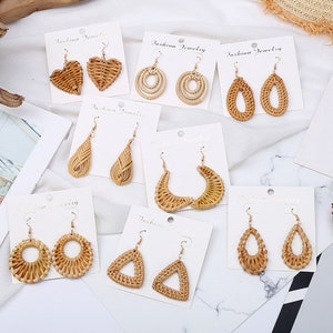 May include: Assortment of 10 pairs of woven wood earrings on white cards with the text "Fashion Jewellery". The earrings are in various shapes, including hearts, teardrops, circles, and triangles.
