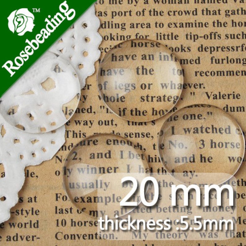 May include: Twenty clear glass cabochons, each measuring 20 mm in diameter and 5.5 mm thick. The cabochons are shown on a printed page with text.