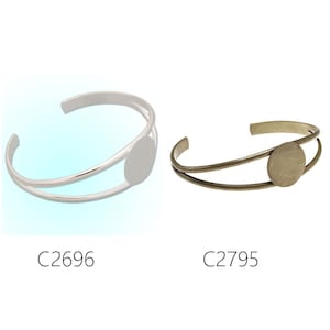 May include: Two silver and bronze bracelets with a round, open space for a cameo or other embellishment. The bracelets are double-layered and have a simple, elegant design.