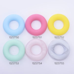 May include: Six silicone rings in different colors: light blue, pink, yellow, light green, light pink, and gray. Each ring has a smooth, rounded surface and a hole in the center. The rings are arranged in two rows of three, with the numbers 10257150, 10257151, 10257152, 10257153, 10257154, and 10257155 printed below each ring.
