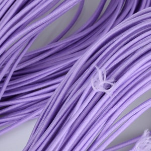 May include: A close-up of a bundle of lavender elastic cord. The cord is soft and flexible, and it is ideal for crafting projects.