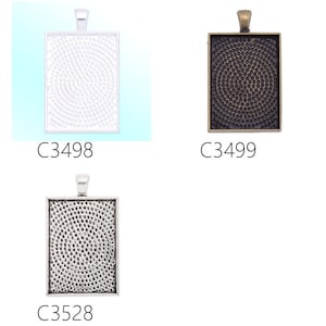 May include: Three silver and bronze pendant trays with a textured surface. The trays are rectangular and have a loop at the top for hanging. The trays are labelled C3498, C3499, and C3528.