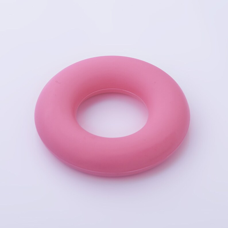 May include: A pink rubber ring, a hand exercise tool.