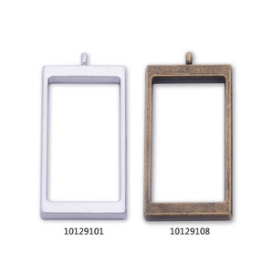 Pode incluir: Dois pingentes de moldura de imagem de metal, um prateado e outro dourado, com um laço na parte superior para pendurar. A moldura prateada tem o código do produto 10129101 e a moldura dourada tem o código do produto 10129108.