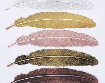 May include: Five metal feather bookmarks in different colors: silver, gold, rose gold, bronze, and copper. Each bookmark has a detailed feather design.
