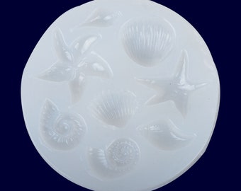 Puede incluir: Molde de silicona blanco con seis formas diferentes con temática marina: dos conchas, dos estrellas de mar y dos conchas en espiral.