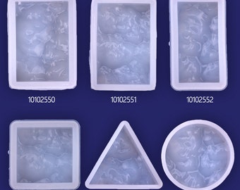 May include: Five clear silicone molds for resin casting. The molds are in the shapes of a square, rectangle, triangle, circle, and a different rectangle. The molds are all on a blue background.
