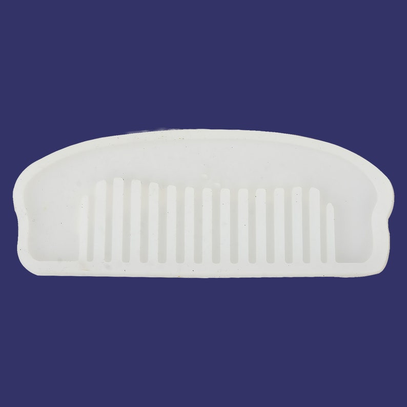 May include: White silicone mold shaped like a comb. The mold is designed to create a comb-shaped object.