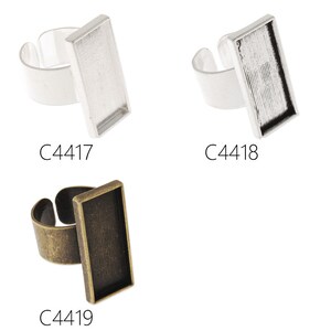 Puede incluir: Tres anillos en blanco de plata y bronce con biseles rectangulares. Los biseles están diseñados para sujetar un pequeño trozo de vidrio u otro material. Los anillos en blanco están etiquetados como C4417, C4418 y C4419.