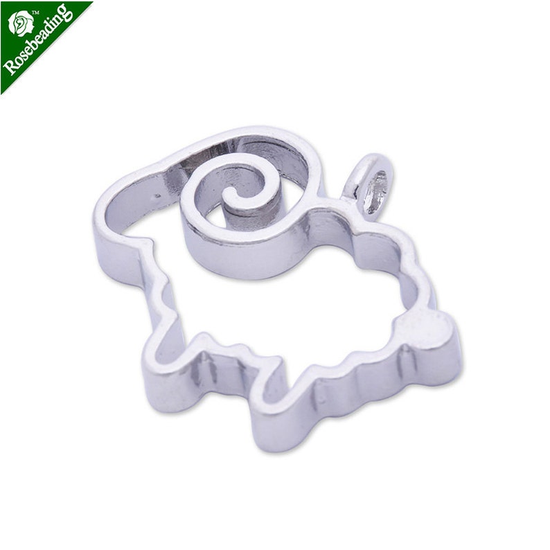 Puede incluir: Encanto de metal plateado en forma de oveja con un cuerno rizado. El encanto tiene un bucle en la parte superior para sujetarlo a un collar o pulsera.