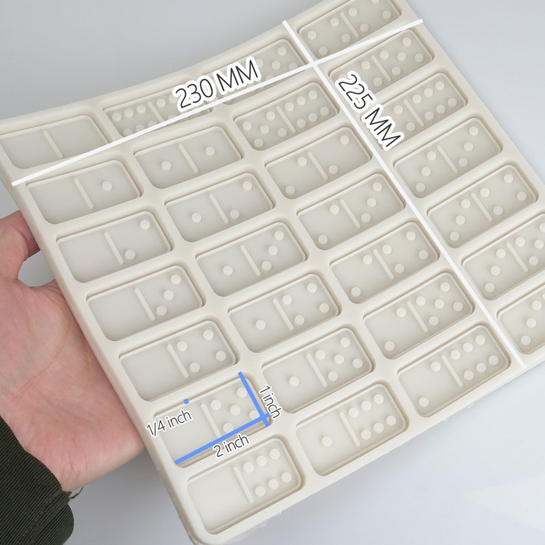 May include: A white silicone domino mold with 28 individual domino cavities. The mold measures 9.06 inches by 8.86 inches.