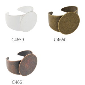Puede incluir: Tres bases de anillo de plata, latón y cobre con un bisel redondo para engastar una piedra cabujón. Las bases de anillo están etiquetadas como C4659, C4660 y C4661.