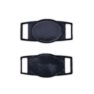 May include: Two black plastic shoe buckles with oval-shaped metal inserts. The buckles have a textured surface.
