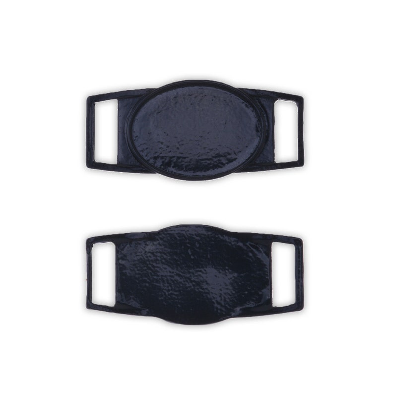May include: Two black plastic shoe buckles with oval-shaped metal inserts. The buckles have a textured surface.