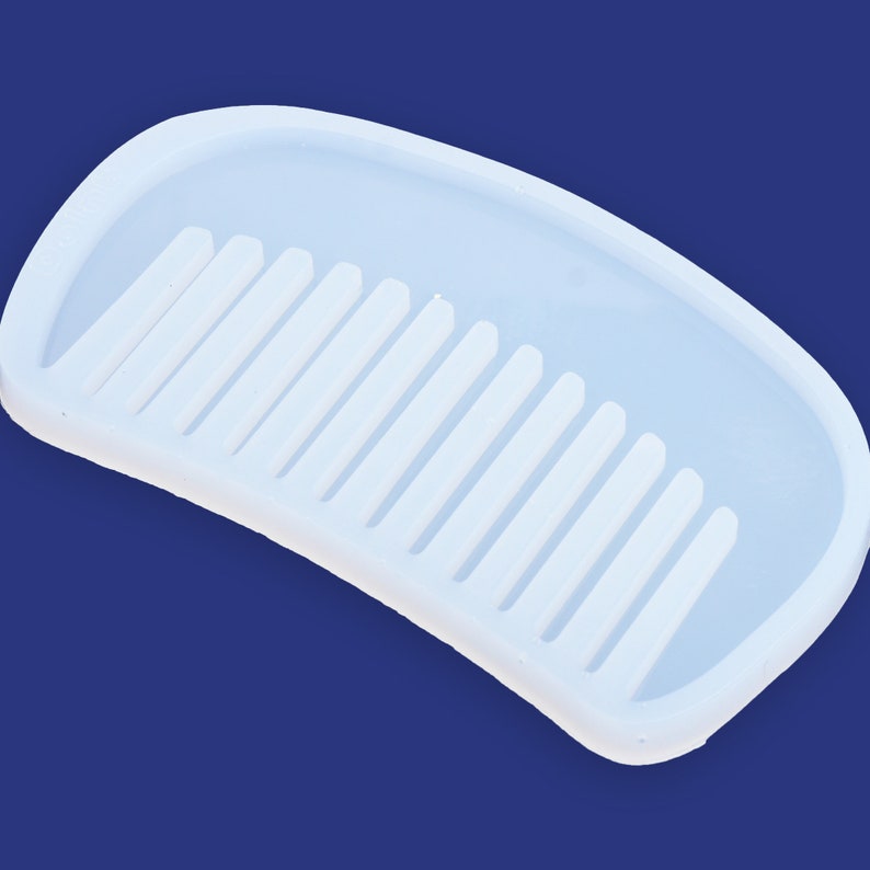 May include: White silicone mold shaped like a comb with 12 teeth. The mold is designed for making resin crafts.