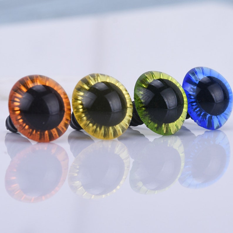 May include: Four plastic safety eyes with black pupils and a shiny finish. The eyes are orange, yellow, green, and blue.