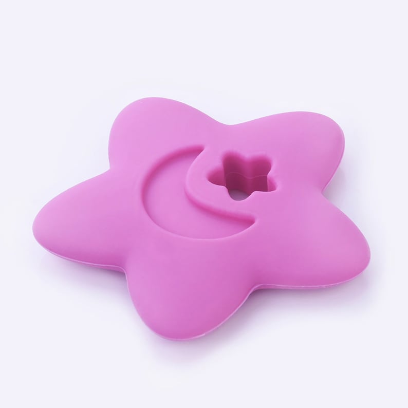 May include: A pink silicone star-shaped teether with a crescent moon and star cutout.