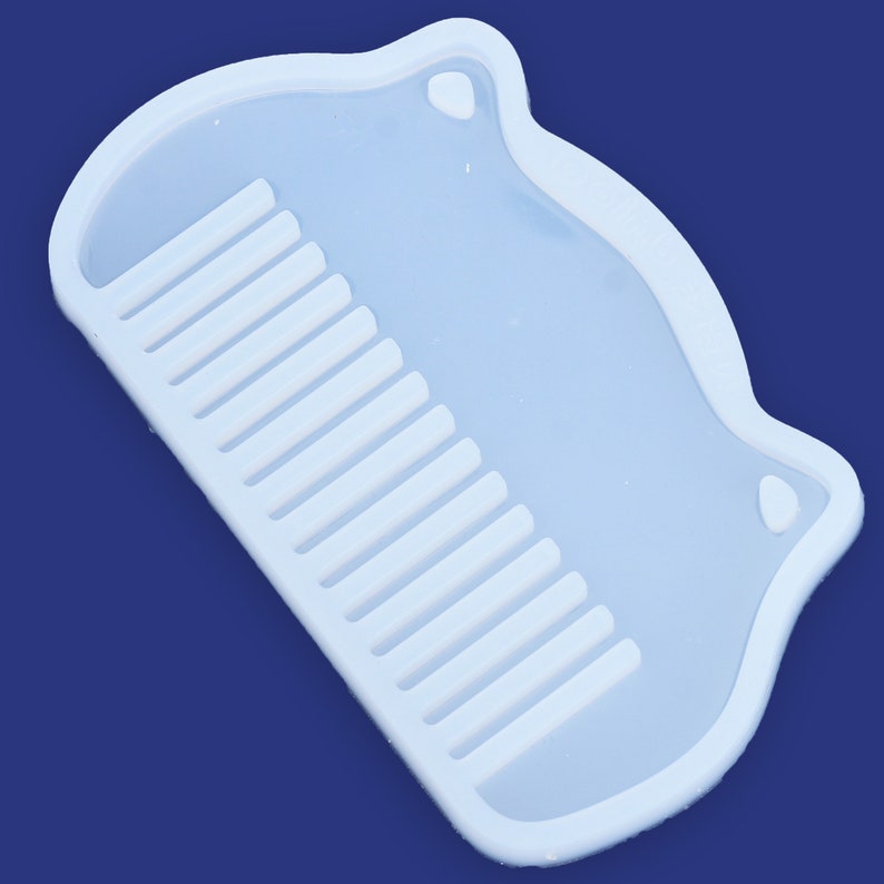 May include: A white silicone mold shaped like a comb. The mold is designed to create a comb-shaped resin piece.