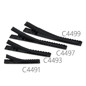 Pode incluir: Quatro grampos de cabelo de metal preto de tamanhos diferentes. Os grampos têm uma borda festonada e são etiquetados com os seguintes códigos de produto: C4499, C4497, C4493 e C4491.