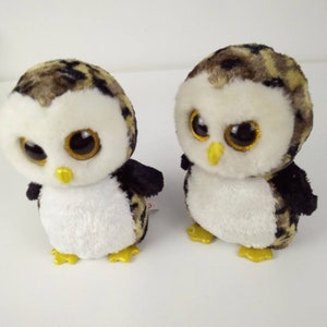May include: Two brown and black owl plush toys with large, glittery eyes. The owls have white bellies and yellow feet.