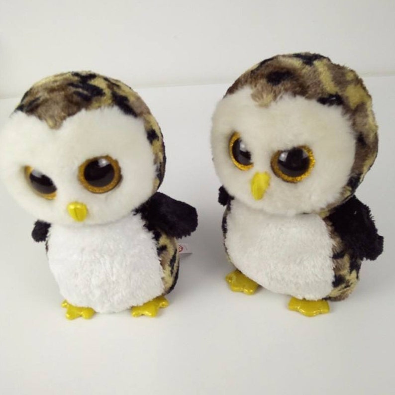 May include: Two brown and black owl plush toys with large, glittery eyes. The owls have white bellies and yellow feet.