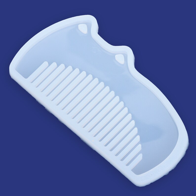 May include: A white silicone mold shaped like a comb with a cat-shaped handle. The mold is designed for making resin crafts.