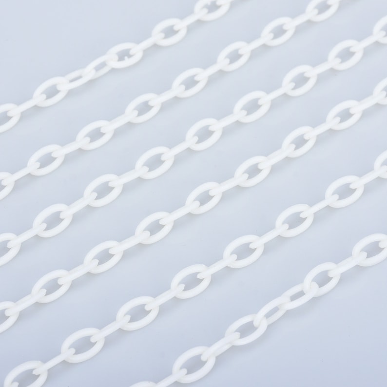 May include: White plastic chain links arranged in parallel lines on a light grey background.