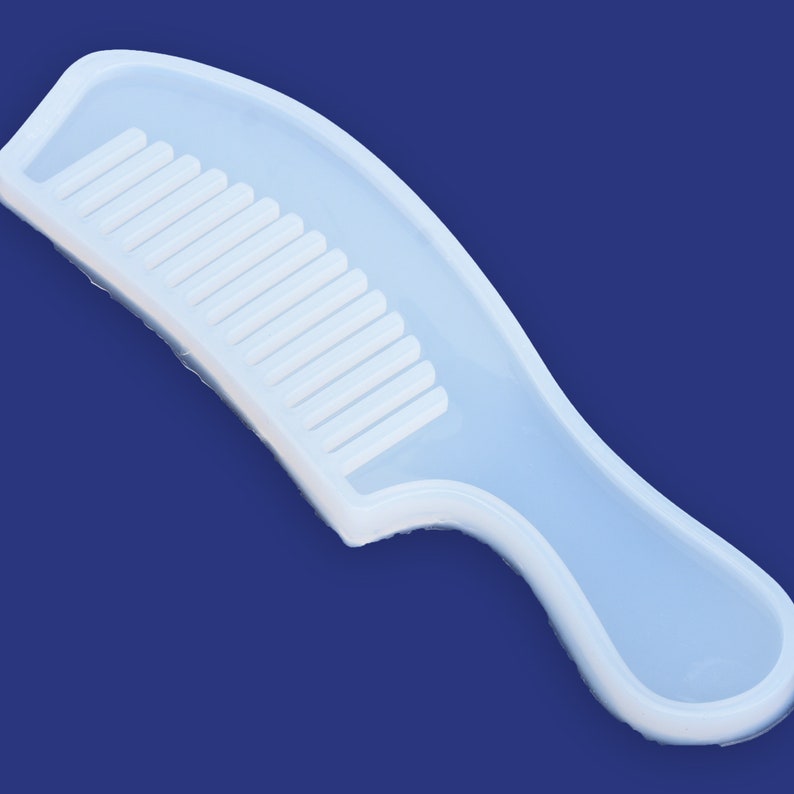 May include: White silicone mold shaped like a comb with a curved handle. The mold is designed for making resin crafts.