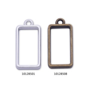 May include: Two rectangular metal frames with a loop at the top. The frame on the left is silver and the frame on the right is gold. The product numbers are 10128501 and 10128508.