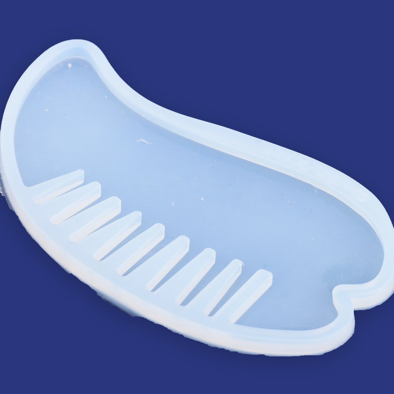 May include: A clear silicone mold shaped like a comb with a row of teeth. The mold is designed for making resin crafts.