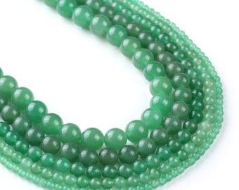 Peut inclure: Un ensemble de perles de jade vert de différentes tailles, disposées en cercle. Les perles sont lisses et polies, d'une couleur verte naturelle.