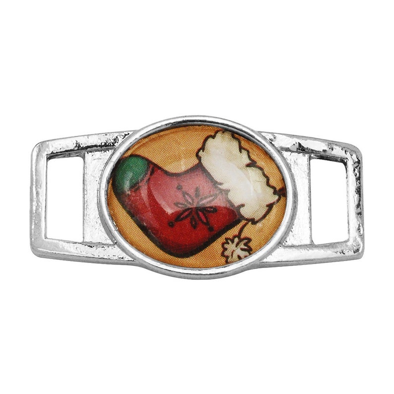 May include: Silver shoe charm with a round, colorful image of a Christmas stocking with a green top and white fur trim.