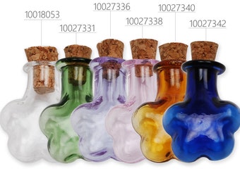 May include: Six small glass bottles with cork stoppers in various colors, including clear, green, purple, pink, amber, and blue. The bottles are shaped like a flower with five petals.