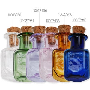 May include: Six small square glass bottles with cork stoppers. The bottles are clear, green, purple, pink, amber, and blue.